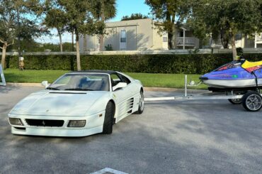 A white [Ferrari 348 TS] pulling a Yamaha wave runner