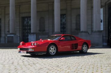 a [ferrari testarossa] outside 'autoworld' in brussels