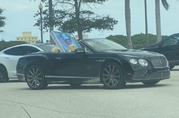 [Bentley Continental GT Convertible] with mud on it and a TV sticking out